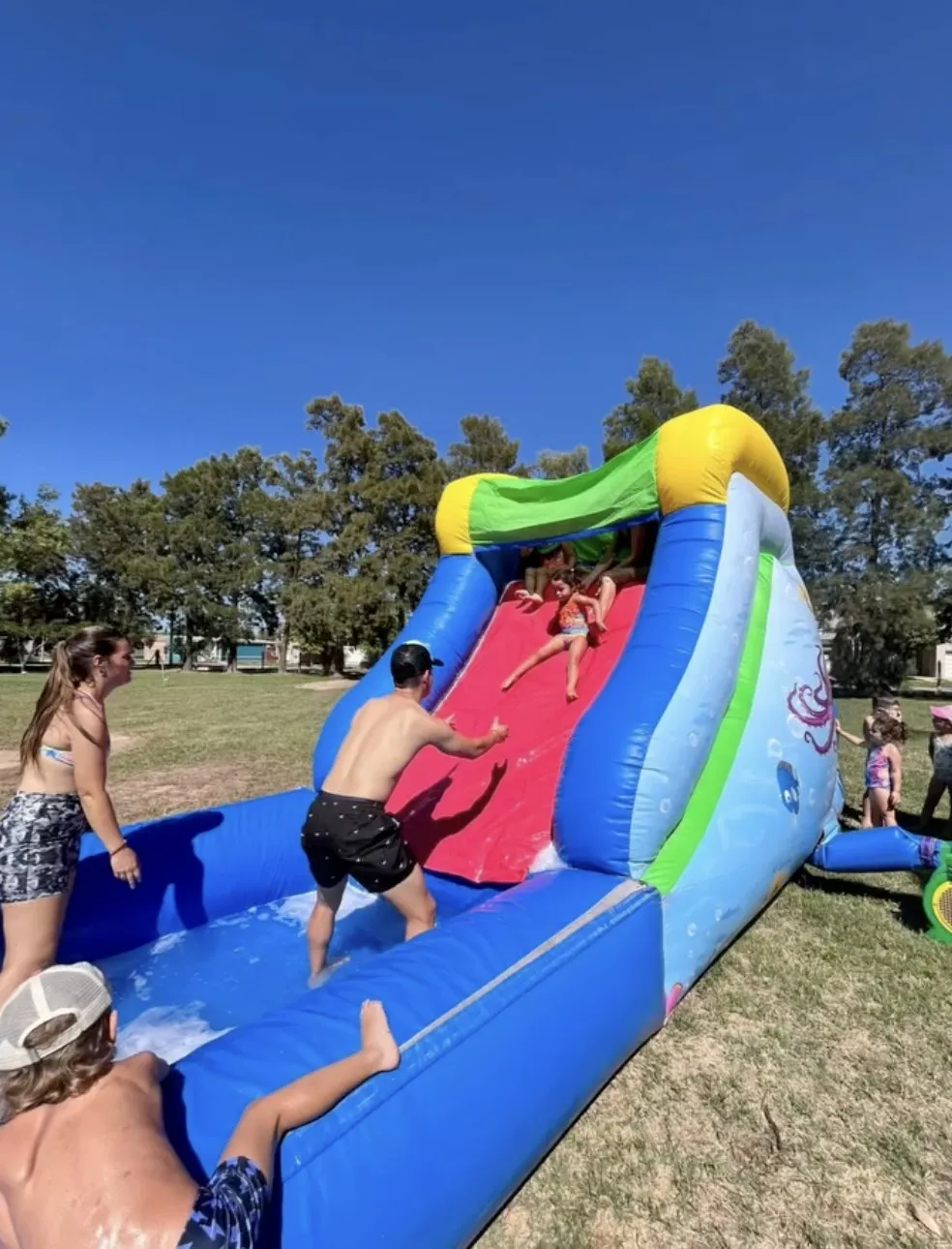 Chico subiendo a un tobogán inflable al aire libre
