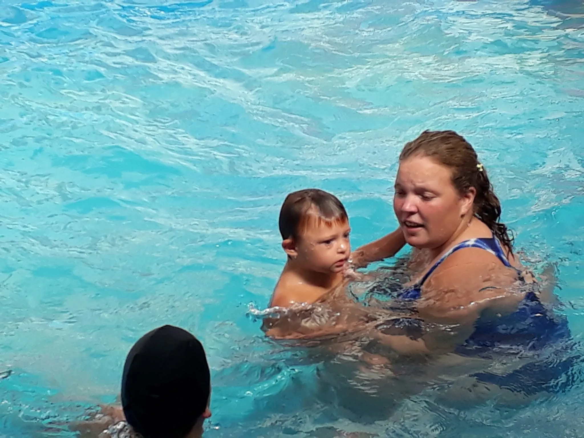 Instructora enseñando a nadar a un nene