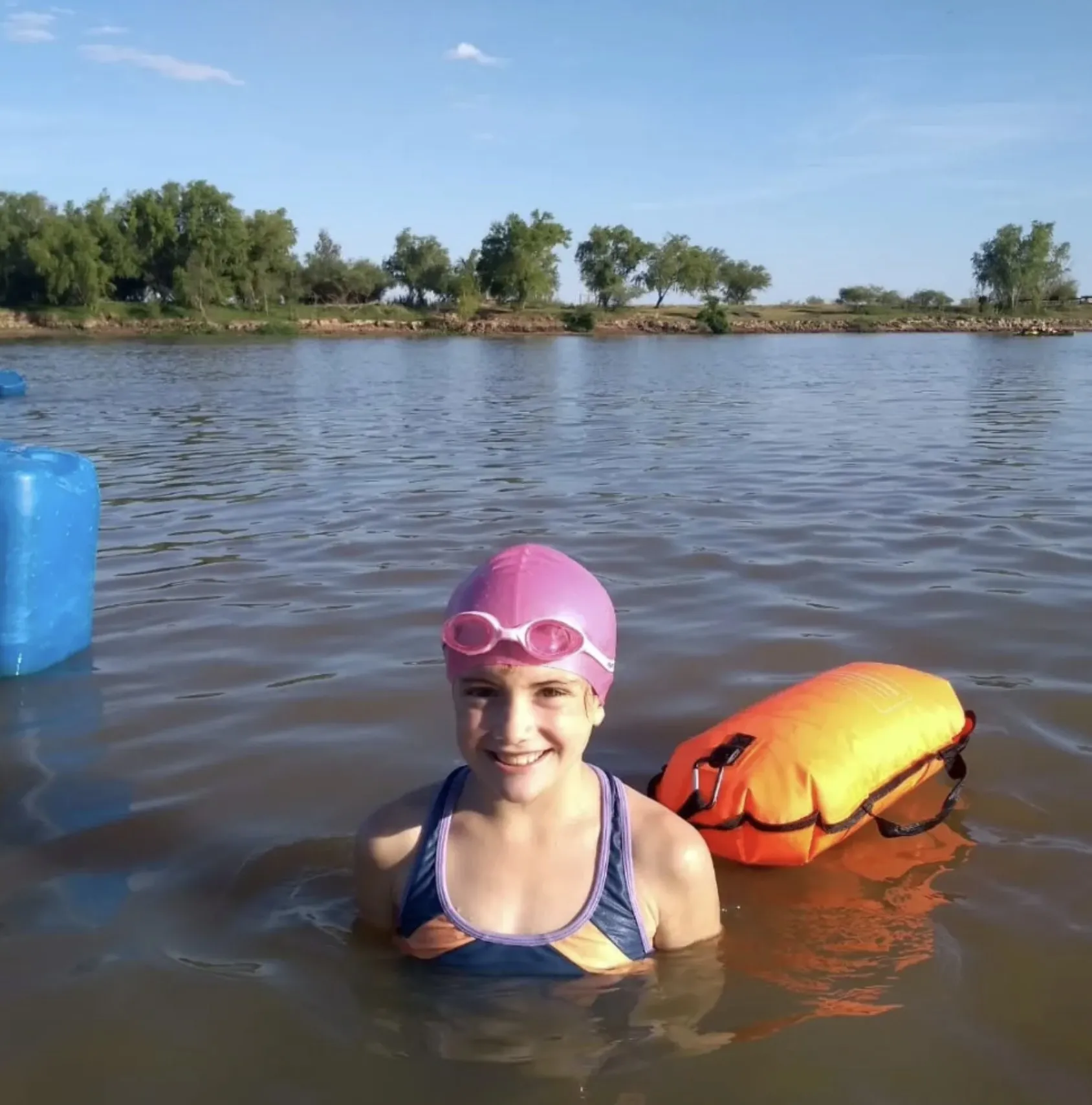 Nadadora de Atlantis sonriendo en el río con su boya de arrastre